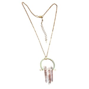 May include: A gold-toned necklace featuring a pendant with a circular frame and three clear, pointed crystal pendants. The necklace has an adjustable chain and a lobster clasp. The crystals have a subtle pink hue.