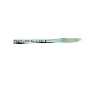 May include: A silver butter knife with a floral pattern on the handle. The knife features a smooth, curved blade and a decorative design of small flowers and leaves along the handle's edge. The knife is set against a white background.