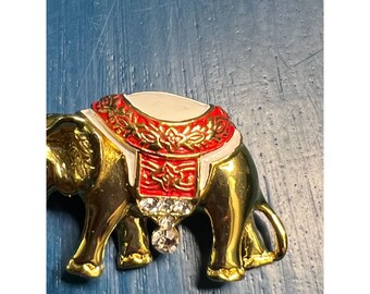 MAGNIFIQUE Broche métal doré, strass et pierres orange
