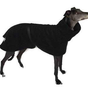 May include: Black fleece dog coat with a high neck and a strap across the chest. The coat is designed for a greyhound.