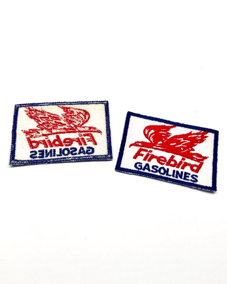 May include: Two vintage Firebird Gasolines patches. The patches are white with blue borders and feature a red bird in flight. The text "Firebird Gasolines" is embroidered in red.