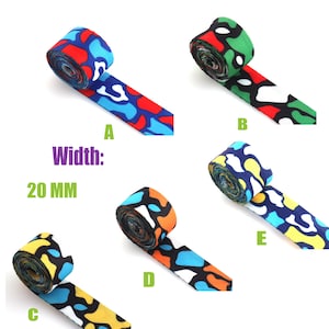 May include: Five rolls of colorful camouflage patterned ribbon, each 20 mm wide. The ribbon is available in five different color combinations: red, blue, and white; green, white, and red; yellow, white, and blue; orange, white, and black; and blue, white, and yellow.