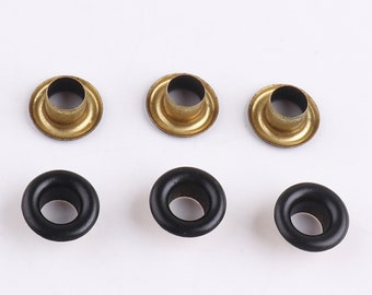 May include: Six metal eyelets, three are gold and three are black. The eyelets are round with a hole in the center.