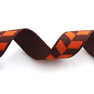 May include: Brown and orange striped ribbon with a woven texture.