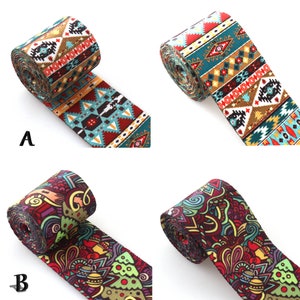 Puede incluir: Dos rollos de cinta de tela con patrones coloridos. La primera cinta tiene un patrón geométrico en tonos de rojo, azul, amarillo y blanco. La segunda cinta tiene un patrón más abstracto en tonos de rojo, verde, azul y amarillo. Ambas cintas están enrolladas y listas para ser utilizadas en proyectos de manualidades.