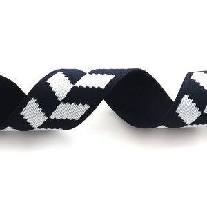 May include: A black and white checkered ribbon with a woven texture. The ribbon is approximately 1 inch wide.