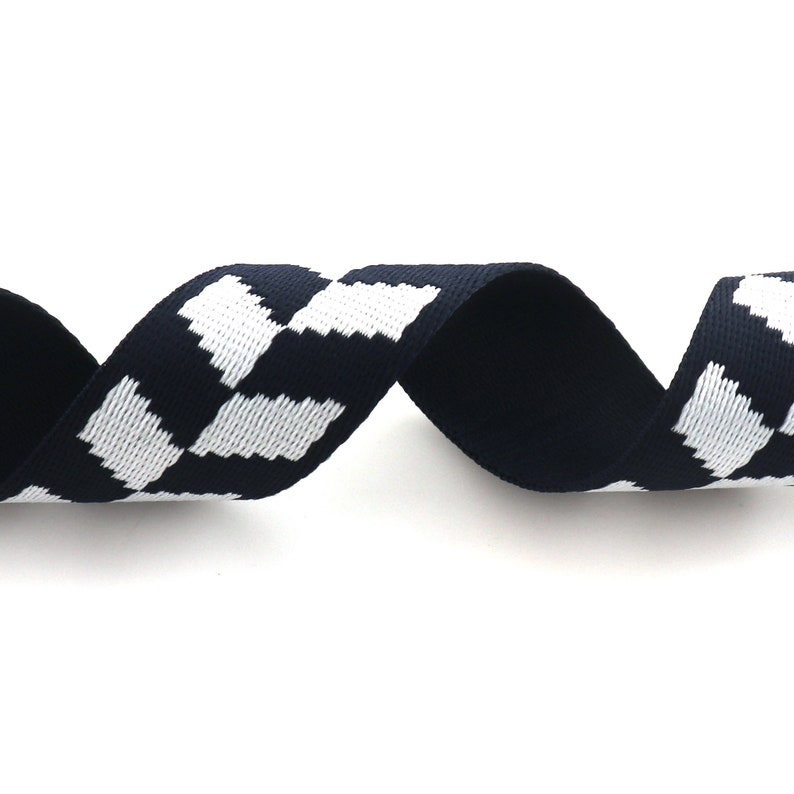 May include: A black and white checkered ribbon with a woven texture. The ribbon is approximately 1 inch wide.