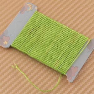 Può includere: Un rocchetto di filo verde brillante con un design a nuvola e stella dei cartoni animati sulla confezione di cartone.