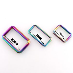 May include: Three rainbow-colored metal rings, measuring 25mm, 38mm, and 40mm in diameter. The rings are rectangular in shape and have a smooth, polished finish.