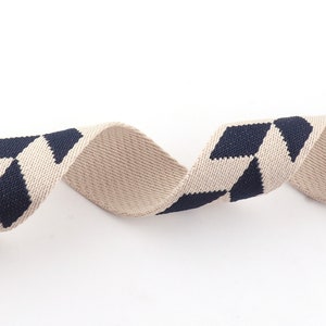 May include: Beige and navy blue woven ribbon with a diamond pattern.
