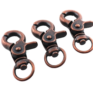 May include: Three antique copper-toned swivel clasps with a spring-loaded gate. These clasps are ideal for attaching to keychains, bags, or other accessories.