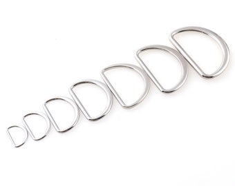 May include: A set of eight silver-toned metal D-rings of varying sizes. The rings are arranged in order of size, with the smallest ring on the left and the largest ring on the right.