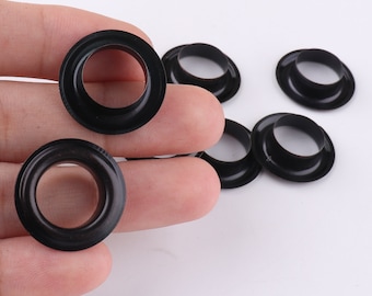 May include: A close-up of six black metal eyelets, commonly used for crafts and DIY projects.