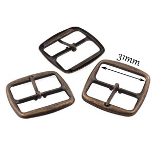 May include: Three antique gold-toned metal belt buckles. The buckle is 31 mm wide.