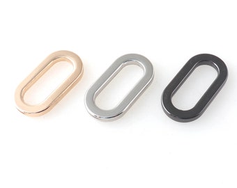 May include: Three oval-shaped metal rings in gold, silver, and black.
