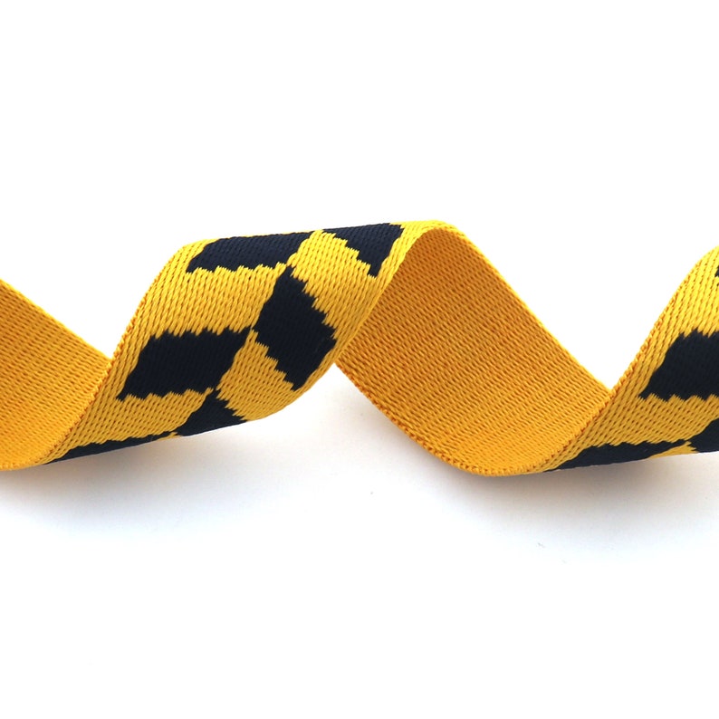 May include: Yellow and black striped elastic webbing. The webbing is woven with a checkered pattern.