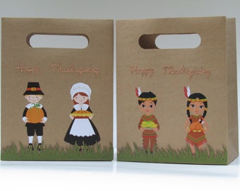 May include: Two brown paper gift bags with cut-out handles. Each bag features a Thanksgiving theme with illustrations of a pilgrim, Native Americans, and the text "Happy Thanksgiving". The bags have a green grass border.