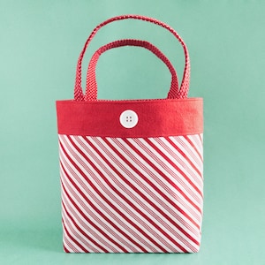 May include: Red and white striped fabric tote bag with a red felt top and a white button.
