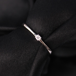 Peut inclure: Une simple bague en argent avec un petit diamant au centre.