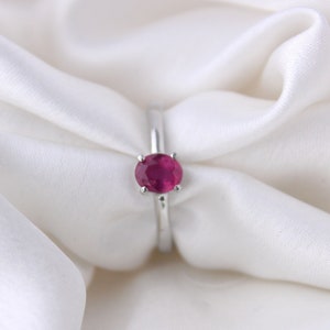 Peut inclure: Une bague en argent avec une pierre ovale rouge.