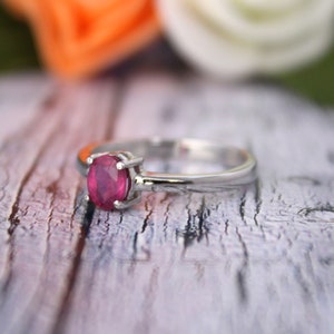 Peut inclure: Une bague en argent avec une pierre pr&eacute;cieuse ovale en rubis rouge fonc&eacute;.