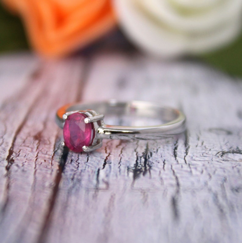 Peut inclure: Une bague en argent avec une pierre pr&eacute;cieuse ovale en rubis rouge fonc&eacute;.