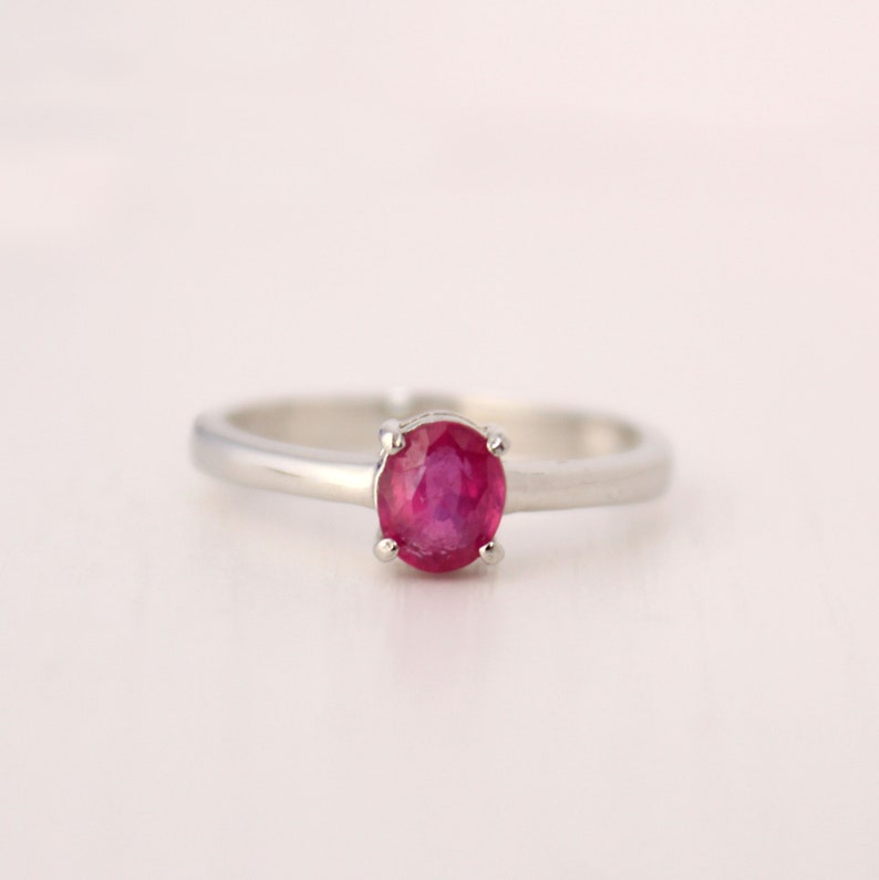 Peut inclure: Une bague en argent avec une pierre pr&eacute;cieuse de rubis rouge ronde.