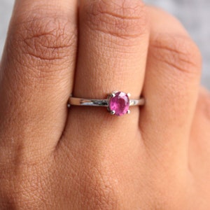 Peut inclure: Une bague en argent avec une pierre pr&eacute;cieuse rose sertie &agrave; griffes.