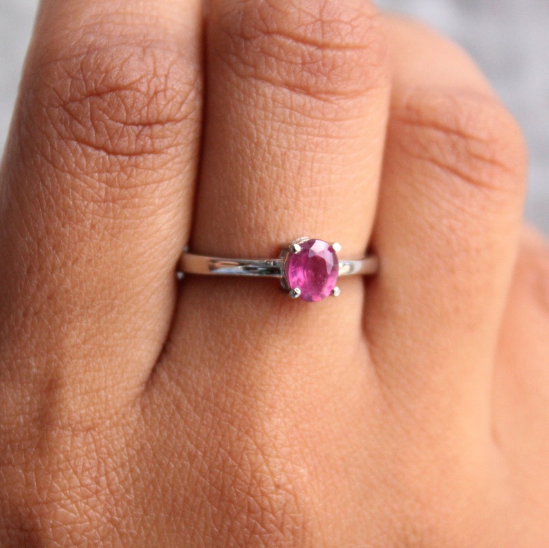 Peut inclure: Une bague en argent avec une pierre pr&eacute;cieuse rose sertie &agrave; griffes.