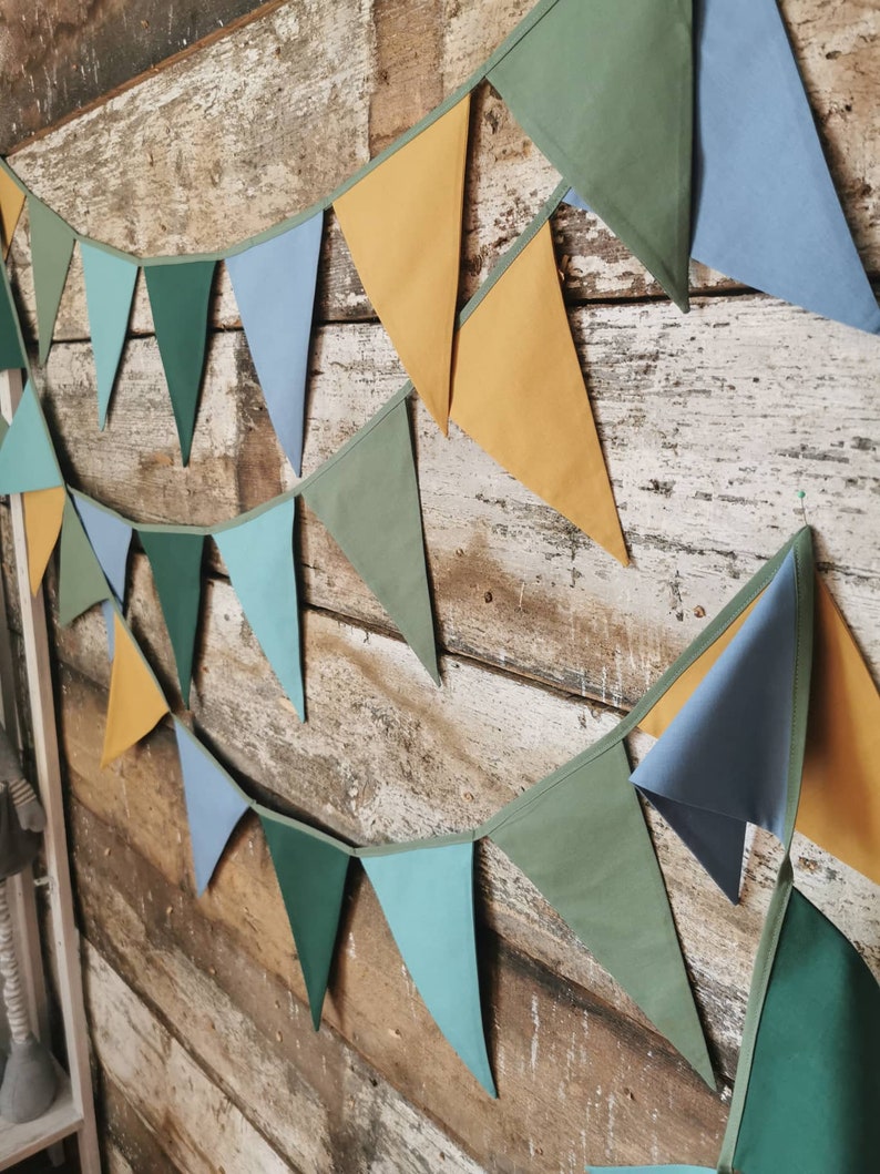 Garland decor will be great accessorie for kids party, baby shower and nursery. Bunting banner made of 100% pure cotton. Triangles are sewn double layer and are handmade. Green, mustard, sea blue dark color. In one metre are 6 pieces of fabric flags.