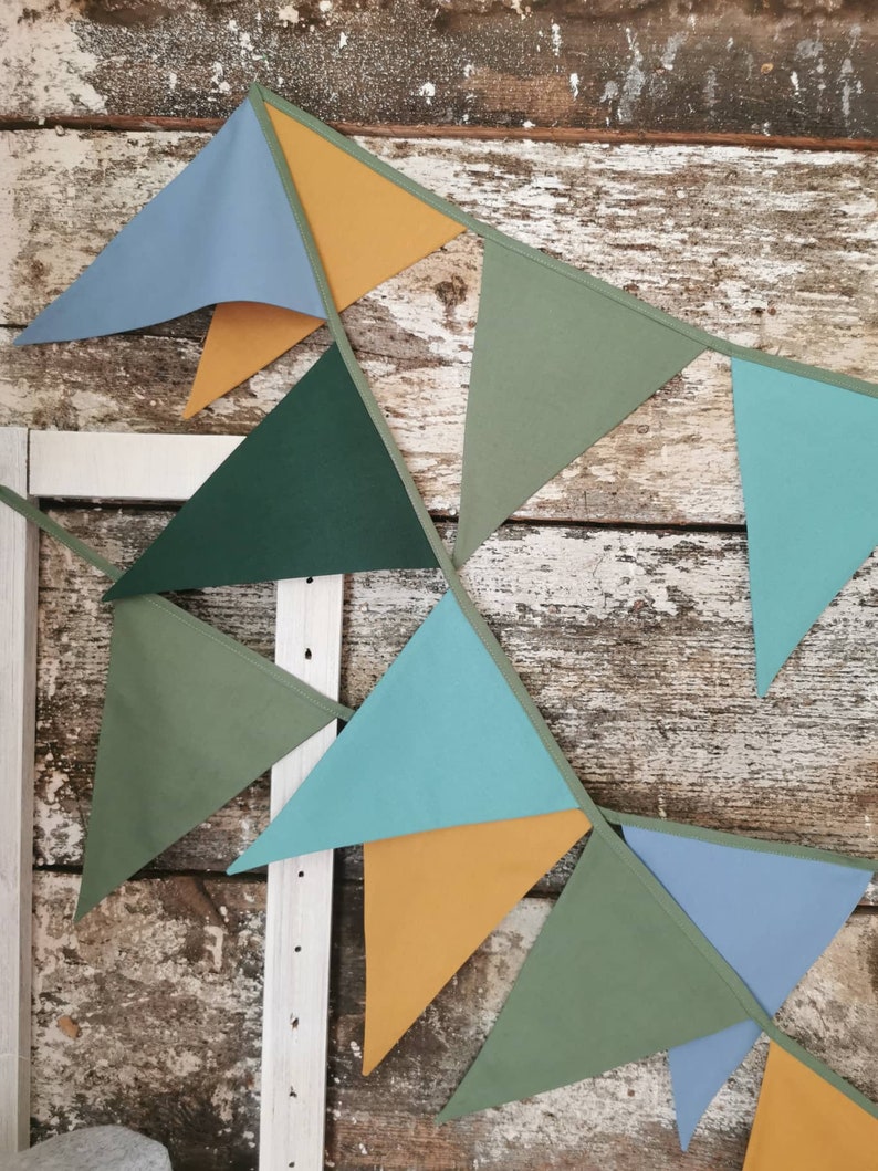 Garland decor will be great accessorie for kids party, baby shower and nursery. Bunting banner made of 100% pure cotton. Triangles are sewn double layer and are handmade. Green, mustard, sea blue dark color. In one metre are 6 pieces of fabric flags.