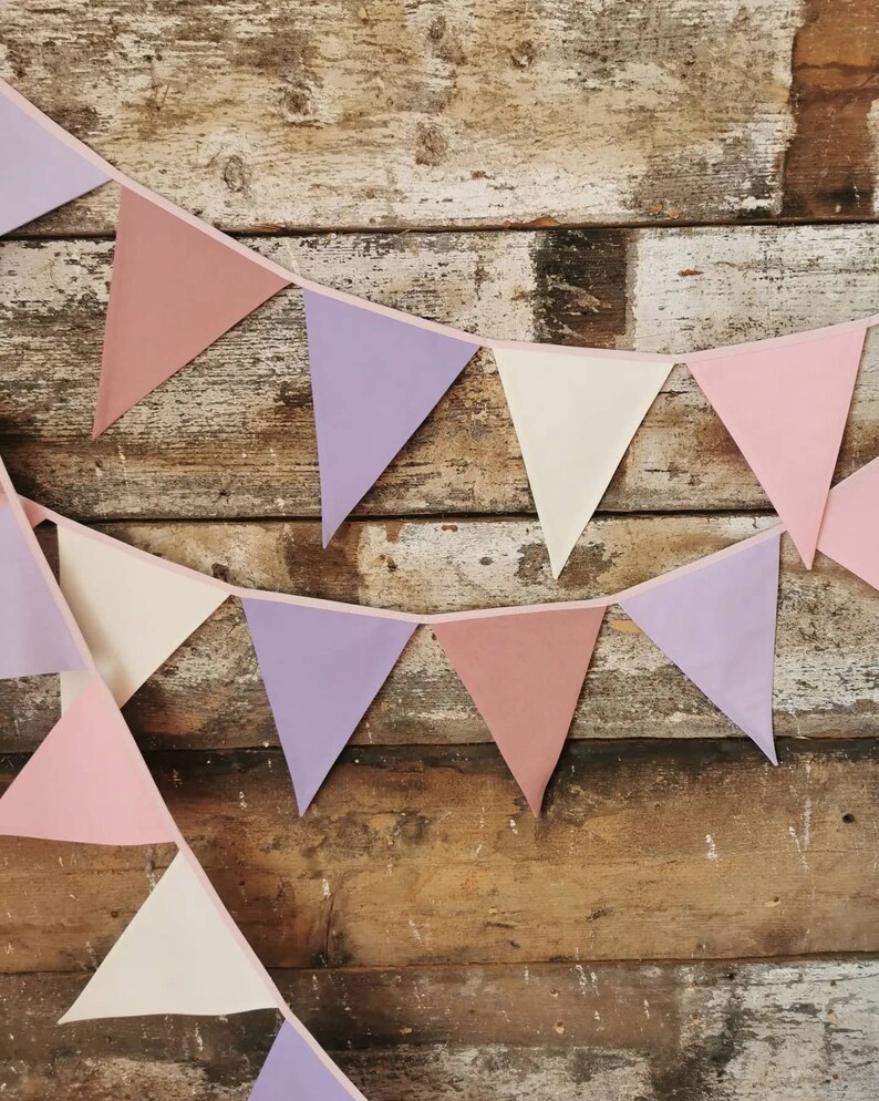 Wall decor will be great accessorie for kids party, baby shower and nursery. Bunting banner made of 100% pure cotton. Triangles are sewn double layer and are handmade. Old pink, violet, off white color. In one metre are 6 pieces of fabric flags.