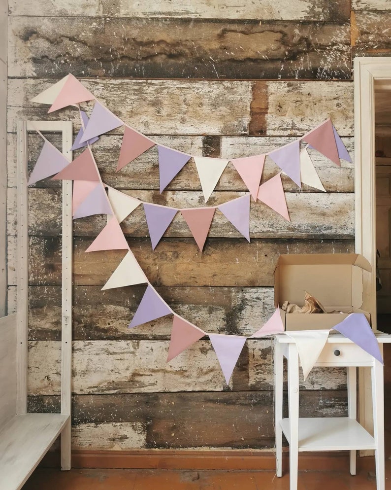 Wall decor will be great accessorie for kids party, baby shower and nursery. Bunting banner made of 100% pure cotton. Triangles are sewn double layer and are handmade. Old pink, violet, off white color. In one metre are 6 pieces of fabric flags.