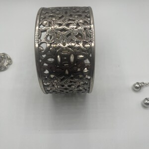 May include: A set of three ceramic mugs with a speckled, matte finish. The mugs are in shades of cream, light gray, and dark gray. Each mug has a simple, minimalist design and a rounded handle.