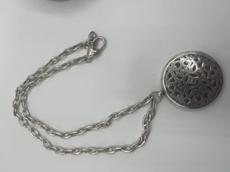 May include: A white ceramic mug with a black handle and the text "But First, Coffee" in a bold, black font. The mug is set against a blurred background, suggesting a cozy setting. The mug appears to be approximately 4 inches tall.