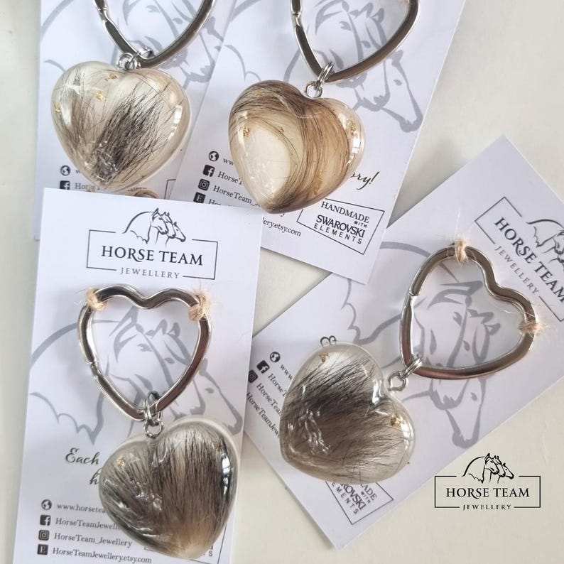 May include: Four silver heart-shaped keychains with clear resin hearts filled with horse hair. Each keychain has a small silver horse charm and the text "Horse Team Jewellery".