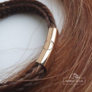 May include: A braided horsehair bracelet with a gold-toned clasp. The bracelet is made of brown horsehair and has a simple, elegant design.