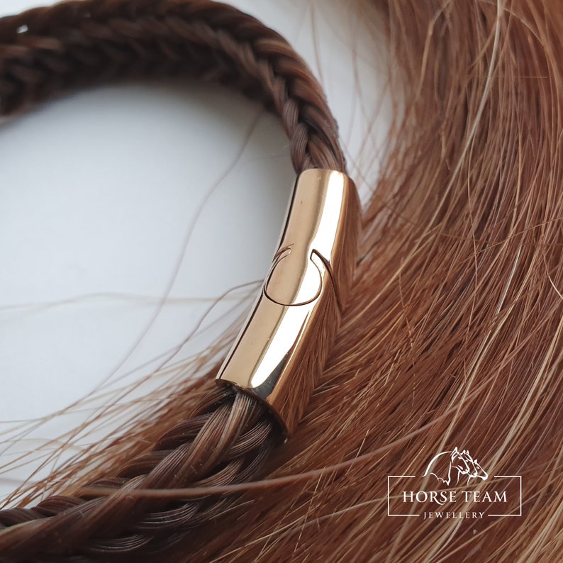 May include: A braided horsehair bracelet with a gold-toned clasp. The bracelet is made of brown horsehair and has a simple, elegant design.