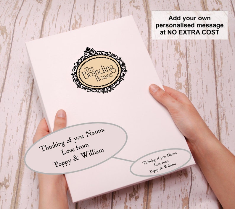 Puede incluir: Tarjeta blanca con un logotipo ornamentado en blanco y negro que dice "The Branding House". La tarjeta tiene un mensaje personalizado que dice "Thinking of you Nanna Love from Poppy & William". La tarjeta tambi&eacute;n tiene una nota que dice "A&ntilde;ade tu propio mensaje personalizado SIN COSTE ADICIONAL".
