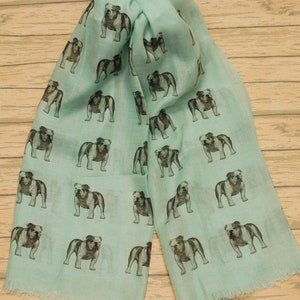 May include: A light blue scarf with a repeating pattern of black and white bulldog illustrations.