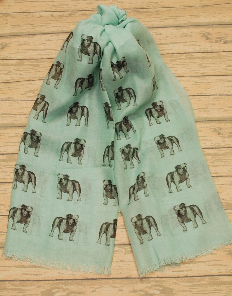 May include: A light blue scarf with a repeating pattern of black and white bulldog illustrations.