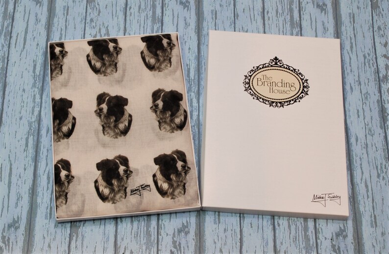 May include: A white gift box with a black and white border collie print scarf inside. The box has the text "The Branding House" on the front and a signature on the bottom.