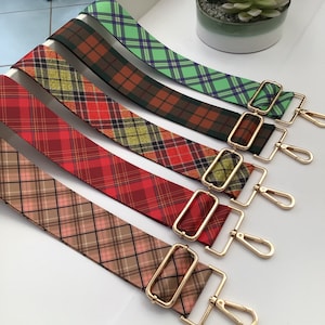 May include: Five different plaid patterned fabric straps with gold metal clasps. The straps are red, green, brown, and pink.