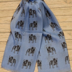 May include: A light blue scarf with a repeating pattern of black and white bulldog illustrations.
