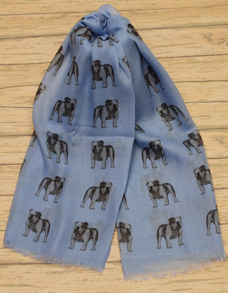 May include: A light blue scarf with a repeating pattern of black and white bulldog illustrations.