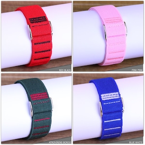 May include: Four elastic watch bands with metal clasps. The bands are red with black stripes, pink with white stripes, green with red stripes, and blue with white stripes.