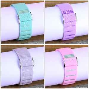 May include: Four different colored elastic watch bands. The bands are turquoise, purple, light grey, and pink turquoise. Each band has a silver buckle.
