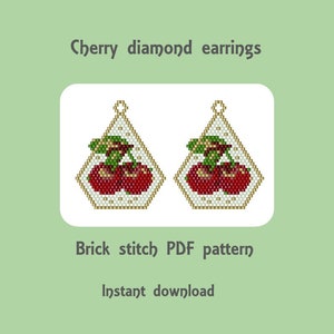 Puede incluir: Un patrón digital para pendientes de punto de ladrillo con cuentas que presenta un par de cerezas rojas con hojas verdes. El patrón está disponible para descarga instantánea. "Cherry diamond earrings" y "Brick stitch PDF pattern" están escritos en la imagen.