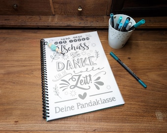 May include: A spiral-bound notebook with a white cover featuring black text that reads Wir sagen Tschüss und Danke für die tolle Zeit! Deine Pandaklasse, decorated with floral motifs and a small turquoise beaded charm attached to the black wire coil.