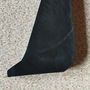 以下が含まれることがあります： 上部に小さな穴のある湾曲した形状の黒いプラスチック製の3Dプリントオブジェクトです